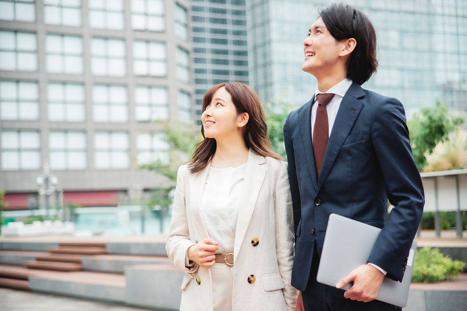 ビル群をバックに、未来への希望に満ちた男女の税理士たちのイメージ写真です。
